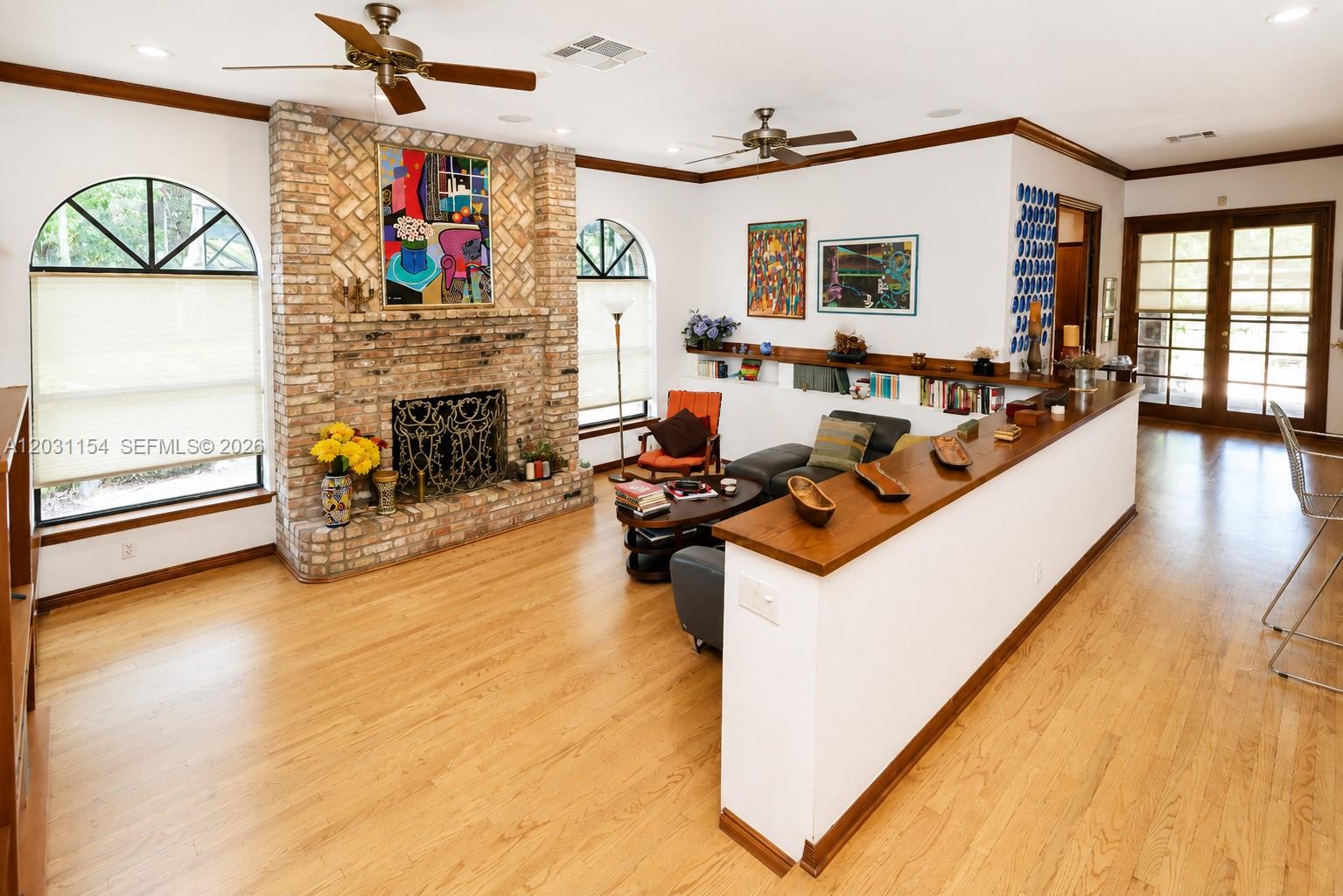 A living room features a brick fireplace, hardwood floors, and a half-wall partition — 5440 Shady Oak Ln, Dania Beach FL 33312, DANIA BEACH, FL