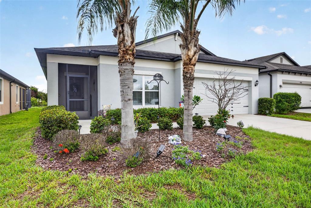 A single-story house with a two-car garage, two palm trees, and a screened front entryway — 11514 LELAND GROVES DRIVE, RIVERVIEW, FL