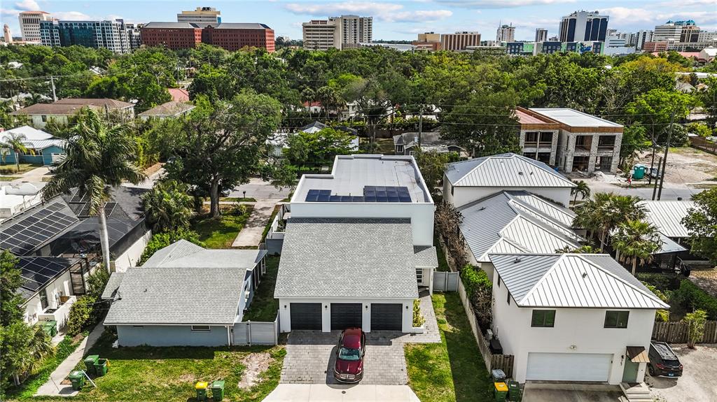 An aerial view shows a modern house with a gray roof and solar panels — 1755 7TH STREET, SARASOTA, FL