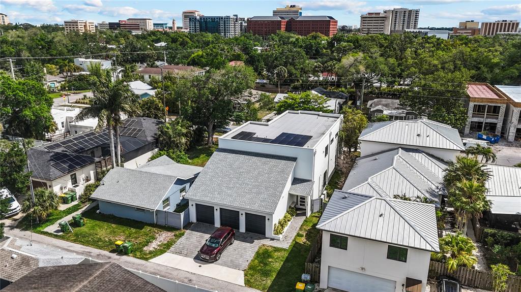 An aerial view shows several modern houses with gray roofs and solar panels in a neighborhood — 1755 7TH STREET, SARASOTA, FL