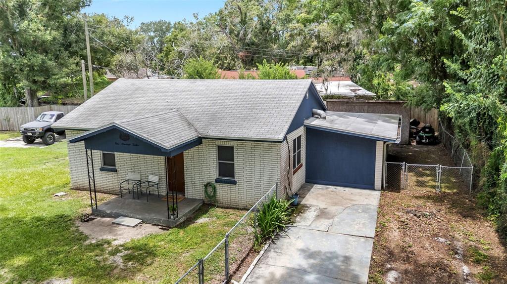 A single-story brick house with a front porch, attached garage, and a concrete driveway — 112 PALM DRIVE, WINTER HAVEN, FL