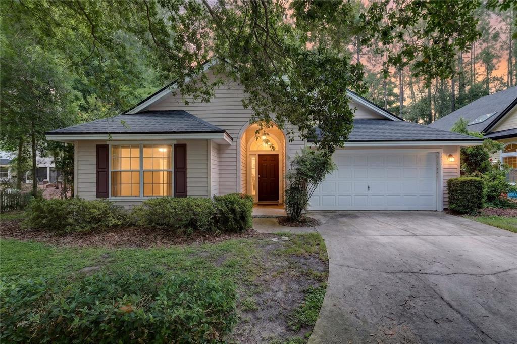 A single-story house with beige siding, a dark roof, and a two-car garage — 9437 SW 31ST LANE, GAINESVILLE, FL
