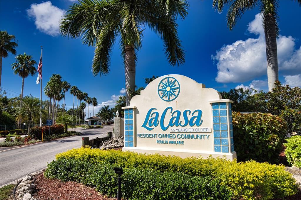 A sign for La Casa, a 55-plus resident-owned community, stands beside a palm-lined entrance road — 418 VIVAR, NORTH PORT, FL