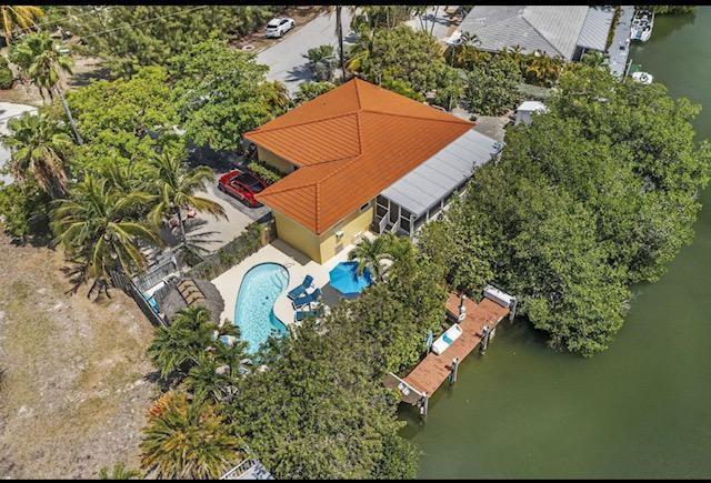 An aerial view of a waterfront house with a pool, dock, and orange roof — 309 W Calzada De Bougainvillea, Marathon FL 33050, MARATHON, FL