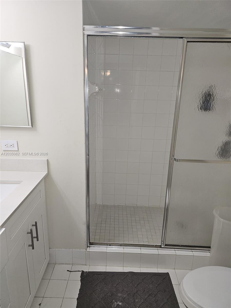 A bathroom features a white vanity, a tiled shower stall, and a toilet — 2031 RENAISSANCE BLVD # 205, Miramar FL 33025, MIRAMAR, FL
