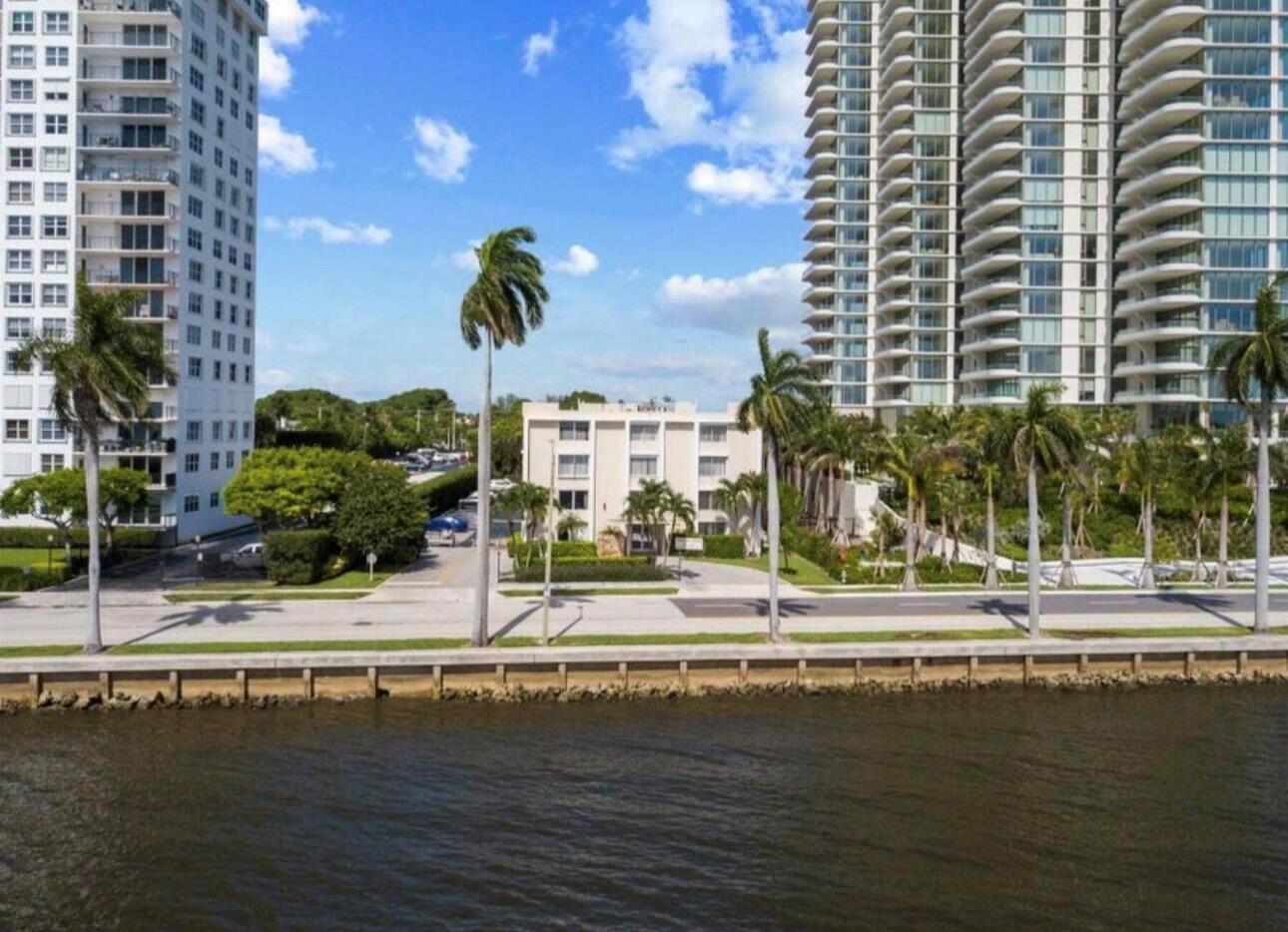 An exterior view of a low-rise building situated between two tall residential towers near water — 1601 S Flagler Drive # 106o, West Palm Beach FL 33401, WEST PALM BEACH, FL