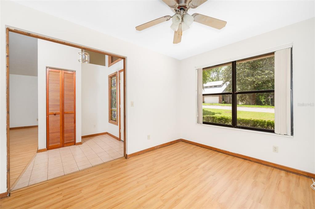 An empty room with light wood-look flooring, a ceiling fan, and a large window — 1301 NW 94TH STREET, GAINESVILLE, FL