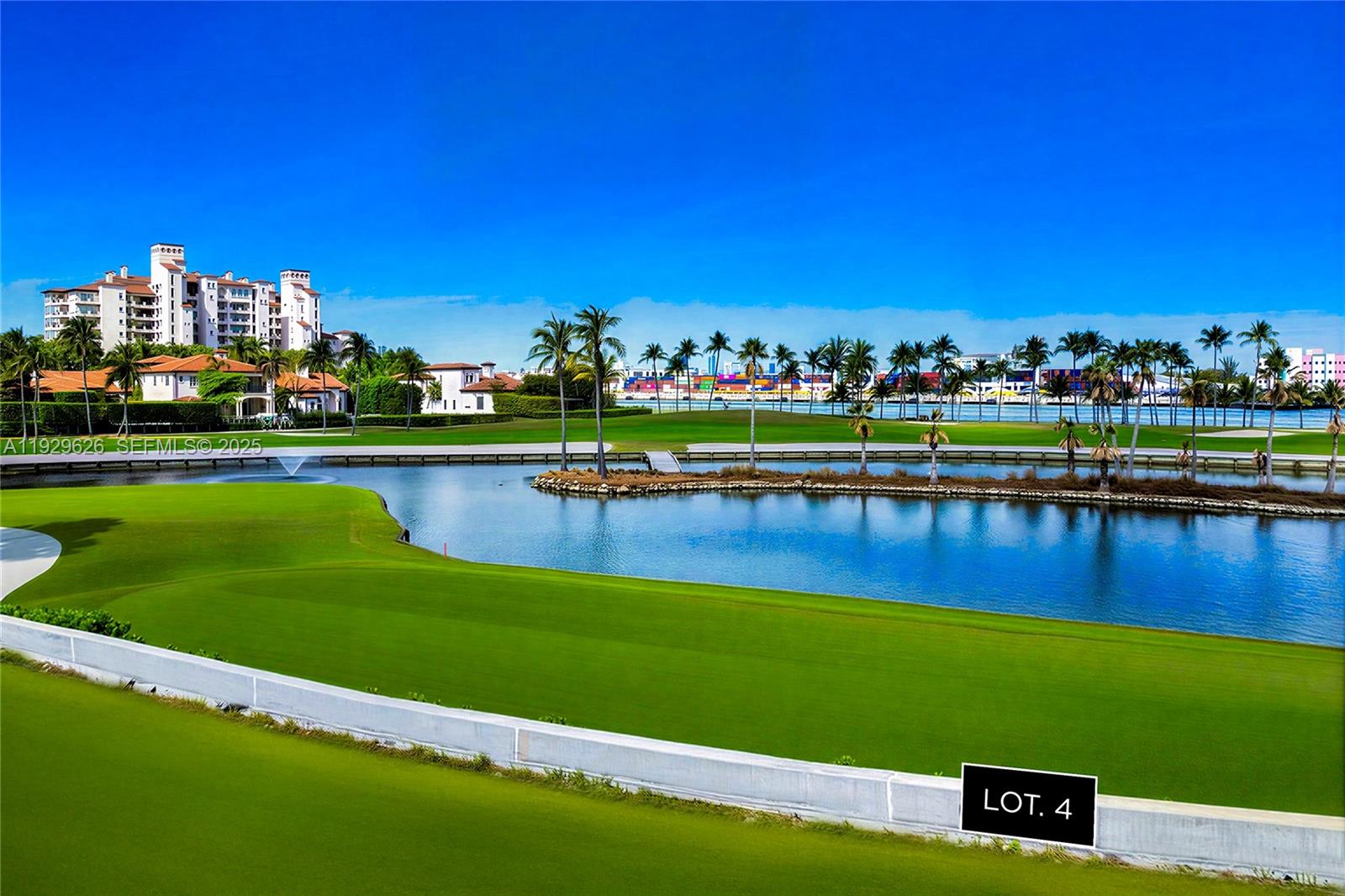 A view of a golf course green, a pond, palm trees, and distant buildings — 1004 Fisher Island Drive, Miami Beach FL 33109, MIAMI BEACH, FL