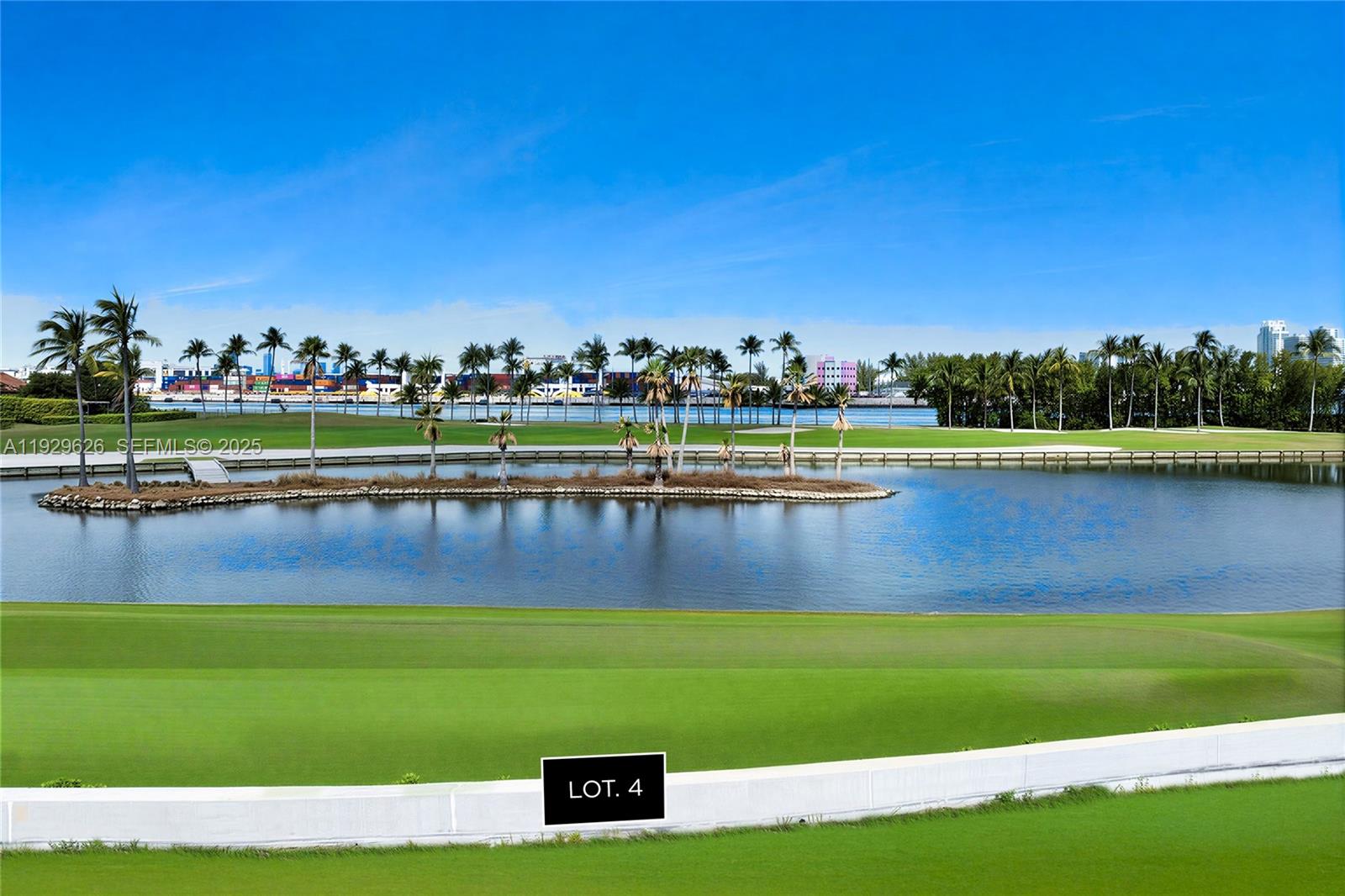 A view of a golf course green, a pond, and palm trees under a clear sky — 1004 Fisher Island Drive, Miami Beach FL 33109, MIAMI BEACH, FL