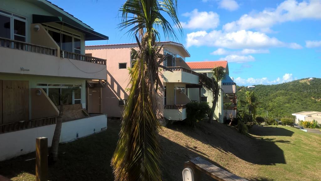 Exterior view of multi-story residential buildings with balconies on a grassy hillside under blue sky — D201 BAHIA MARINA RESORT CONDOMINIUM UNIT D201, CULEBRA, PR