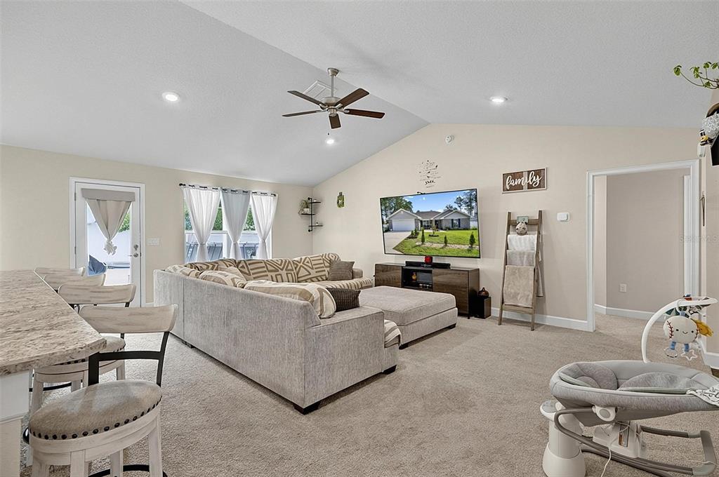 A living room features a sectional sofa, a television, and a breakfast bar area — 33 RICHARDSON DRIVE, PALM COAST, FL