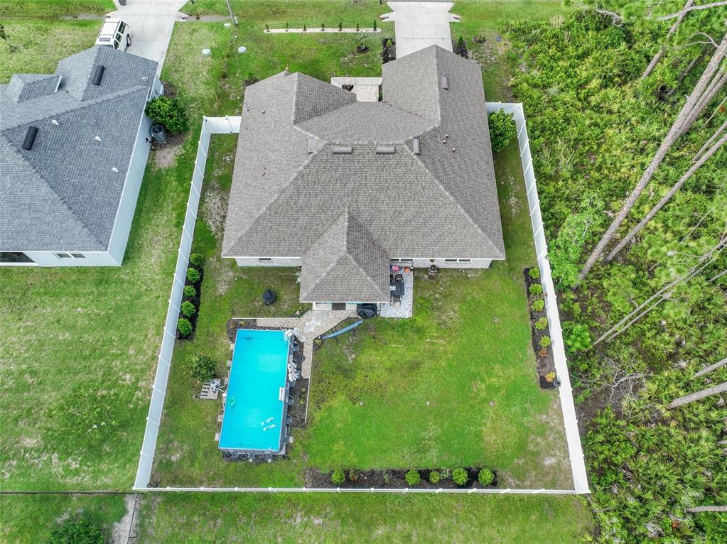 An aerial view shows a house with a shingled roof, a pool, and a fenced yard — 33 RICHARDSON DRIVE, PALM COAST, FL