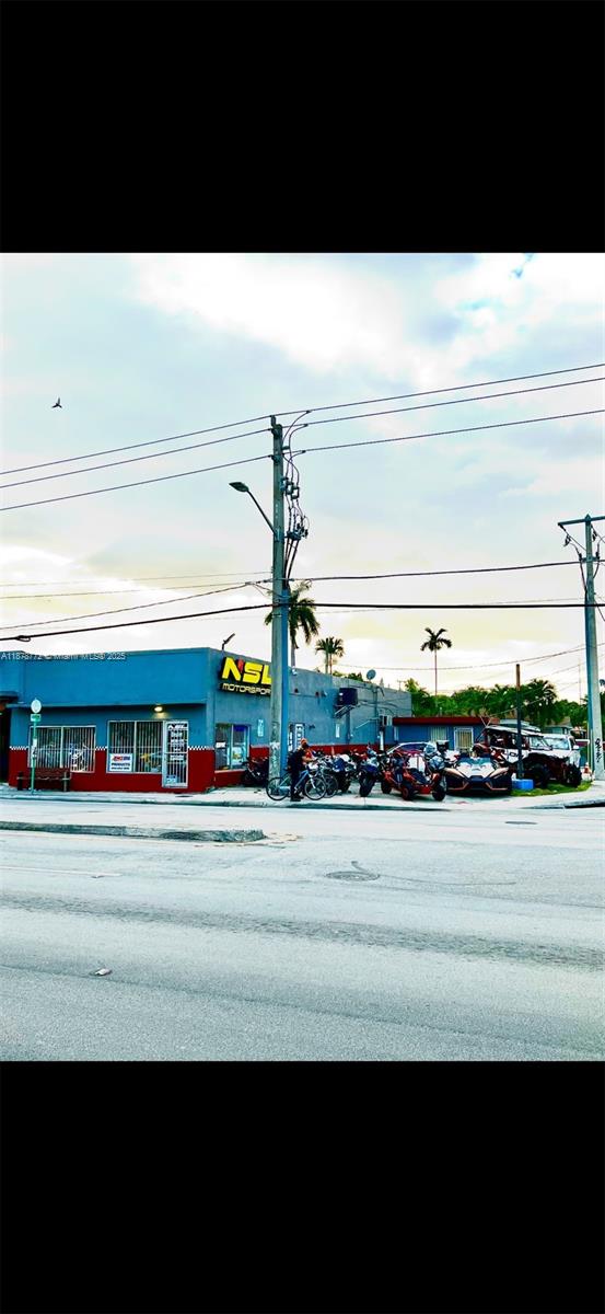 An exterior view of a blue commercial building with a parking lot and power lines — 210 SW 22nd Ave, Miami FL 33135, MIAMI, FL