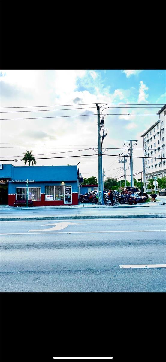A blue and red commercial building sits along a street with parked motorcycles and power lines — 210 SW 22nd Ave, Miami FL 33135, MIAMI, FL