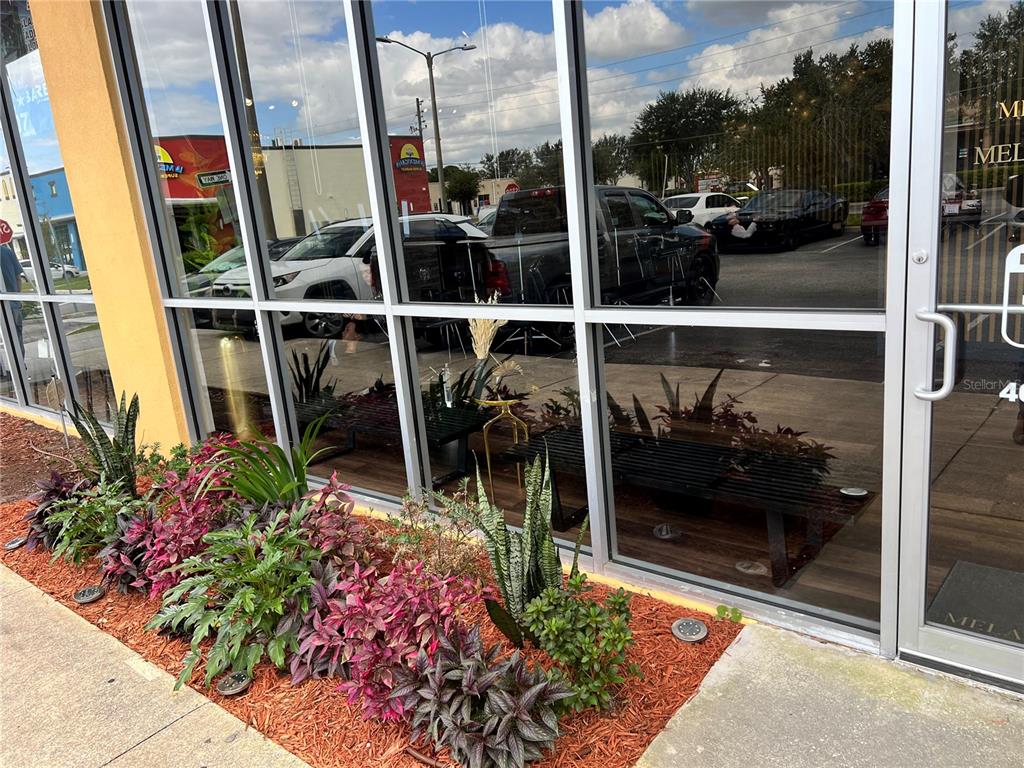A storefront exterior features a glass facade, a metal door, and a landscaped garden bed — 2204 W COLUMBIA AVENUE, KISSIMMEE, FL