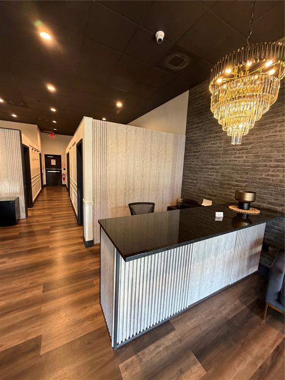 A reception area features a black countertop desk, wood-slat paneling, and a large crystal chandelier — 2204 W COLUMBIA AVENUE, KISSIMMEE, FL
