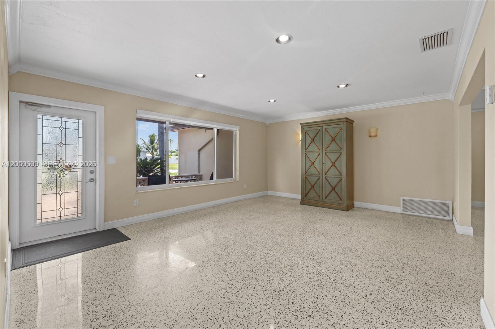 A living room features light-colored walls, recessed lighting, a large window, and speckled flooring — 8431 Pasadena Blvd, Pembroke Pines FL 33024, PEMBROKE PINES, FL