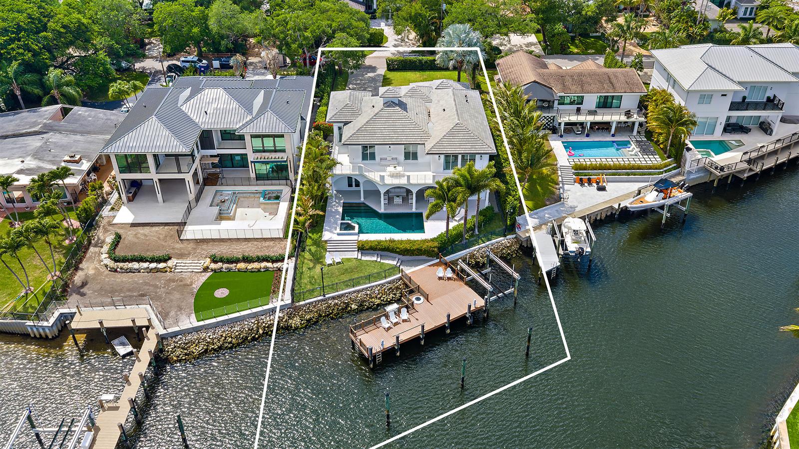 An elevated view of a waterfront backyard featuring a swimming pool, dock, and sunset sky — 12864 S Shore Drive, Palm Beach Gardens FL 33410, PALM BEACH GARDENS, FL
