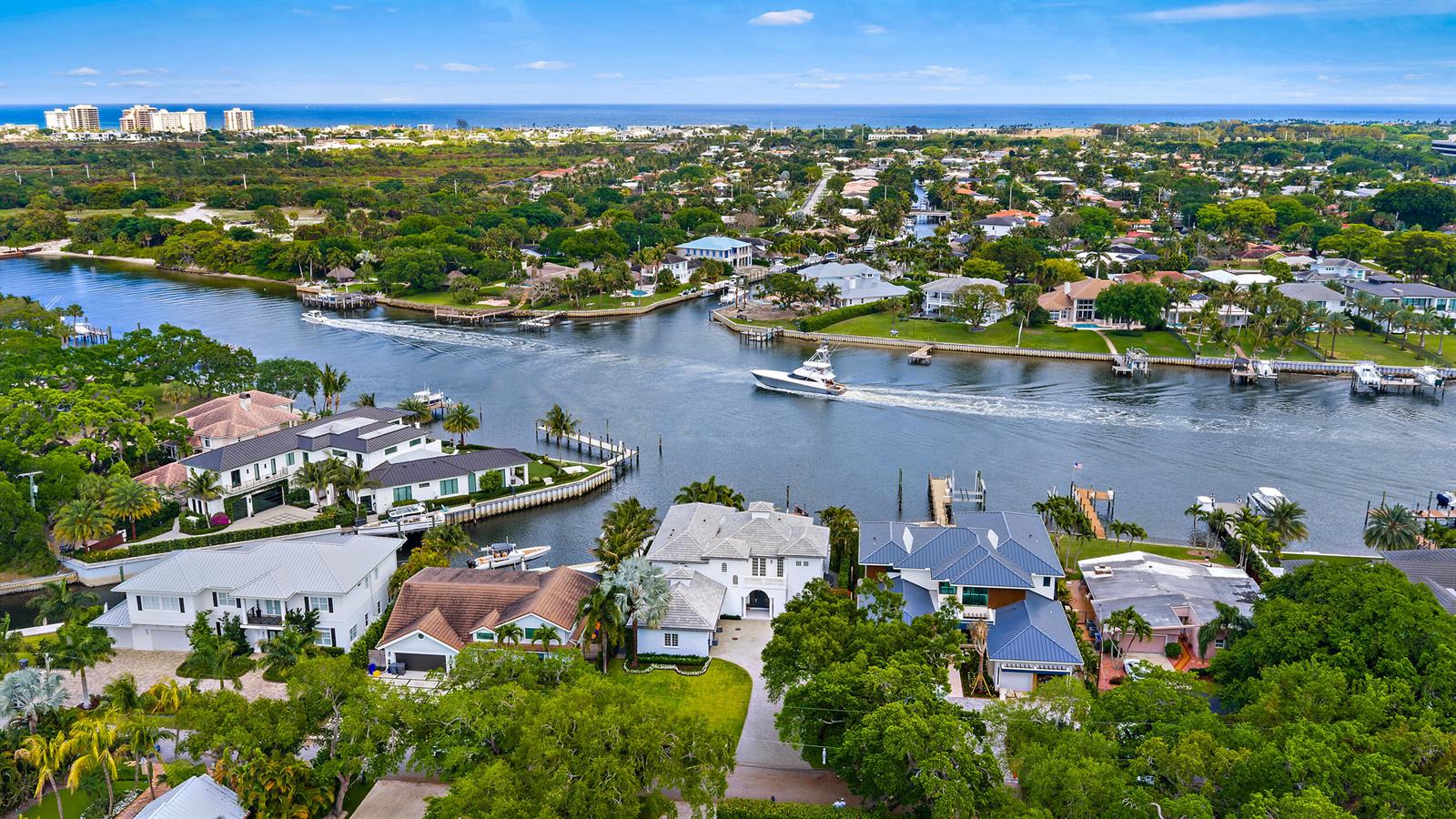 A swimming pool and hot tub overlook a canal with docks and waterfront homes — 12864 S Shore Drive, Palm Beach Gardens FL 33410, PALM BEACH GARDENS, FL