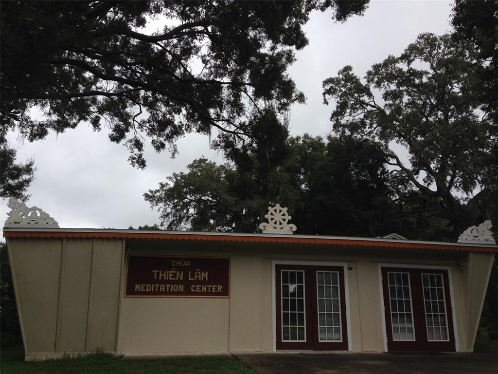 The exterior of a single-story meditation center building features a flat roof and double doors — 2223 KILMER LANE, APOPKA, FL