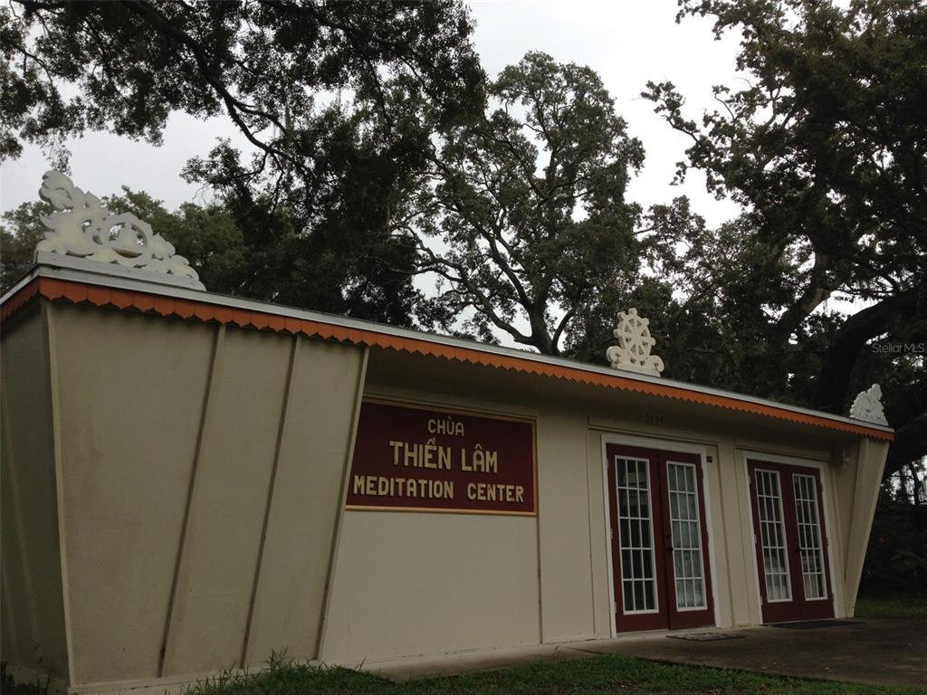 The exterior of the Chua Thien Lam Meditation Center features a tan building with red doors — 2223 KILMER LANE, APOPKA, FL