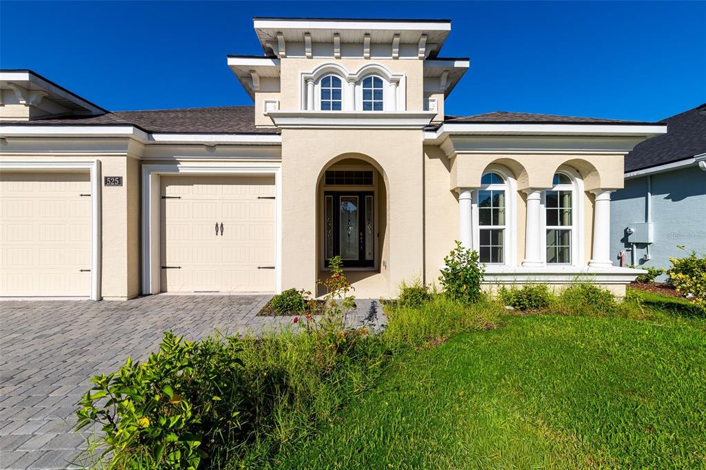 A beige single-story house with a paved driveway, arched entryway, and two front windows — 525 MOSAIC BOULEVARD, DAYTONA BEACH, FL