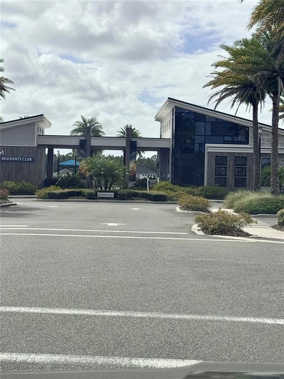 The exterior of a modern residents club building features a covered walkway and palm trees — 525 MOSAIC BOULEVARD, DAYTONA BEACH, FL