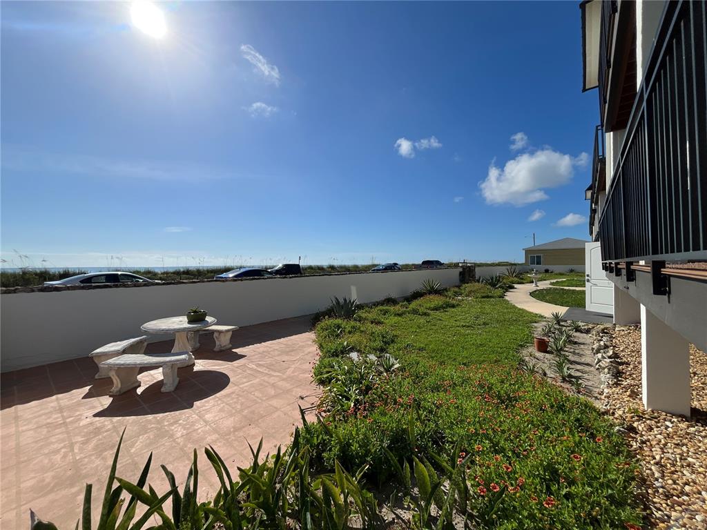 An outdoor patio with a stone table and benches overlooks a beach and ocean — 2139 N OCEAN SHORE BOULEVARD UNIT 2139, FLAGLER BEACH, FL