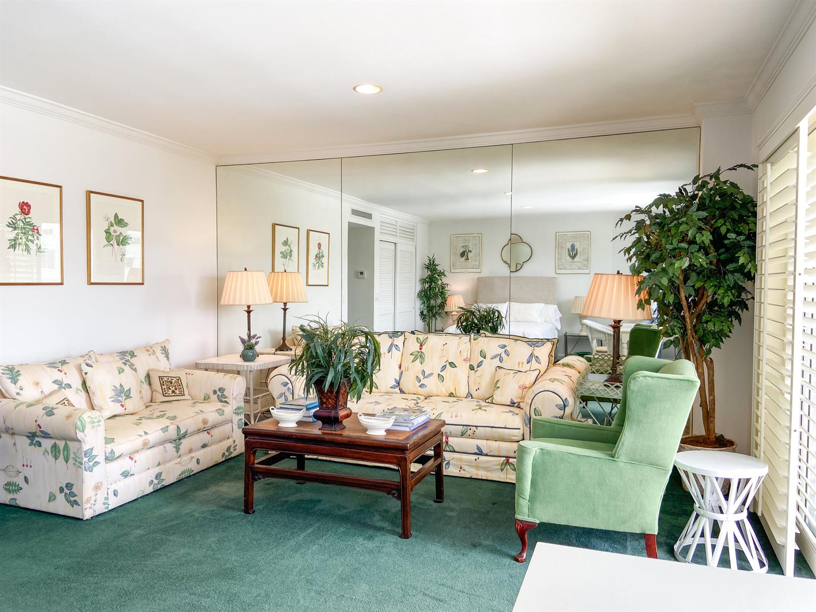 A living room features floral sofas, a green armchair, a coffee table, and mirrored walls — 44 Cocoanut Row # 610a, Palm Beach FL 33480, PALM BEACH, FL