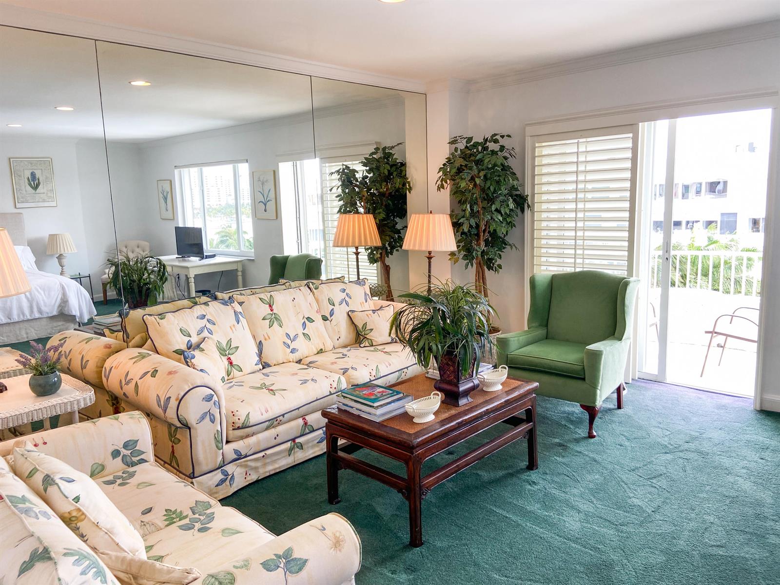 A living room features a floral sofa, green armchair, coffee table, and a large mirrored wall — 44 Cocoanut Row # 610a, Palm Beach FL 33480, PALM BEACH, FL