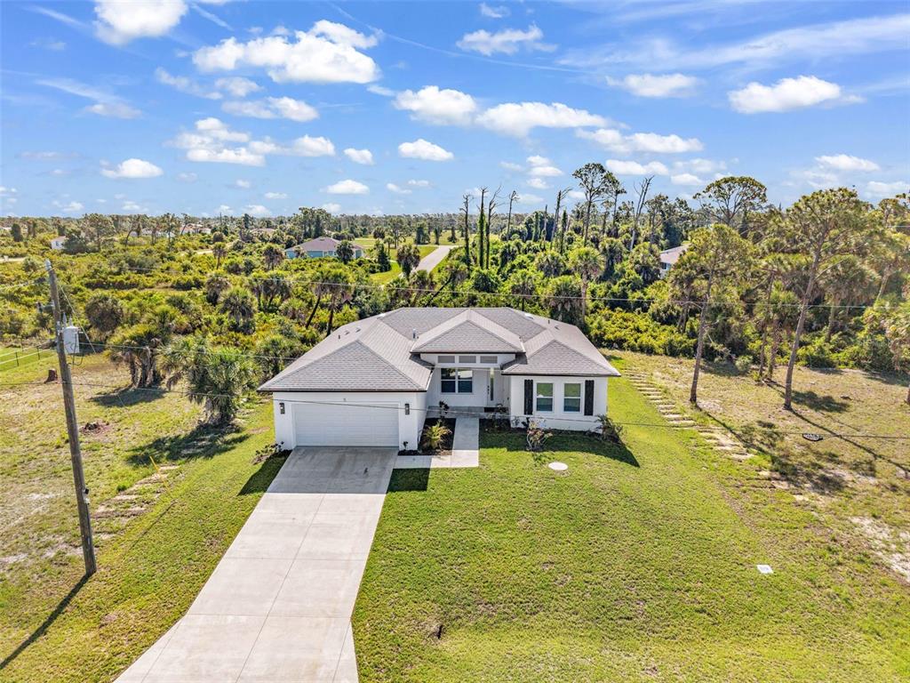 An aerial view shows a single-story house with a white exterior and a gray roof — 5 MATE DRIVE, PLACIDA, FL