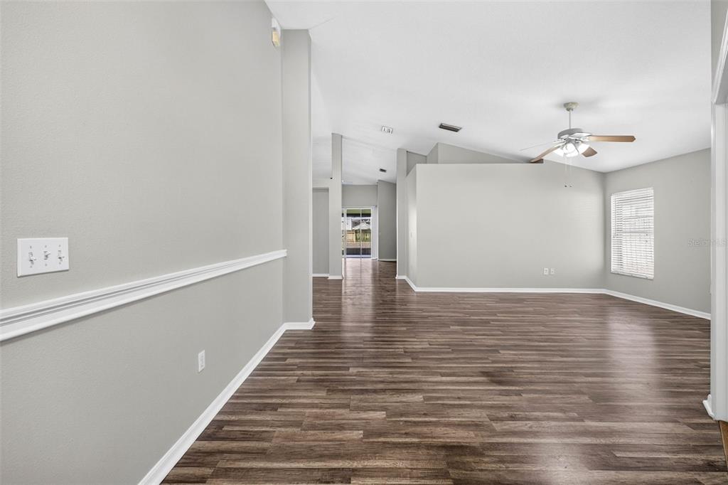 An empty room with gray walls, white trim, and dark wood-look flooring — 2605 VALENCIA GROVE DRIVE, VALRICO, FL