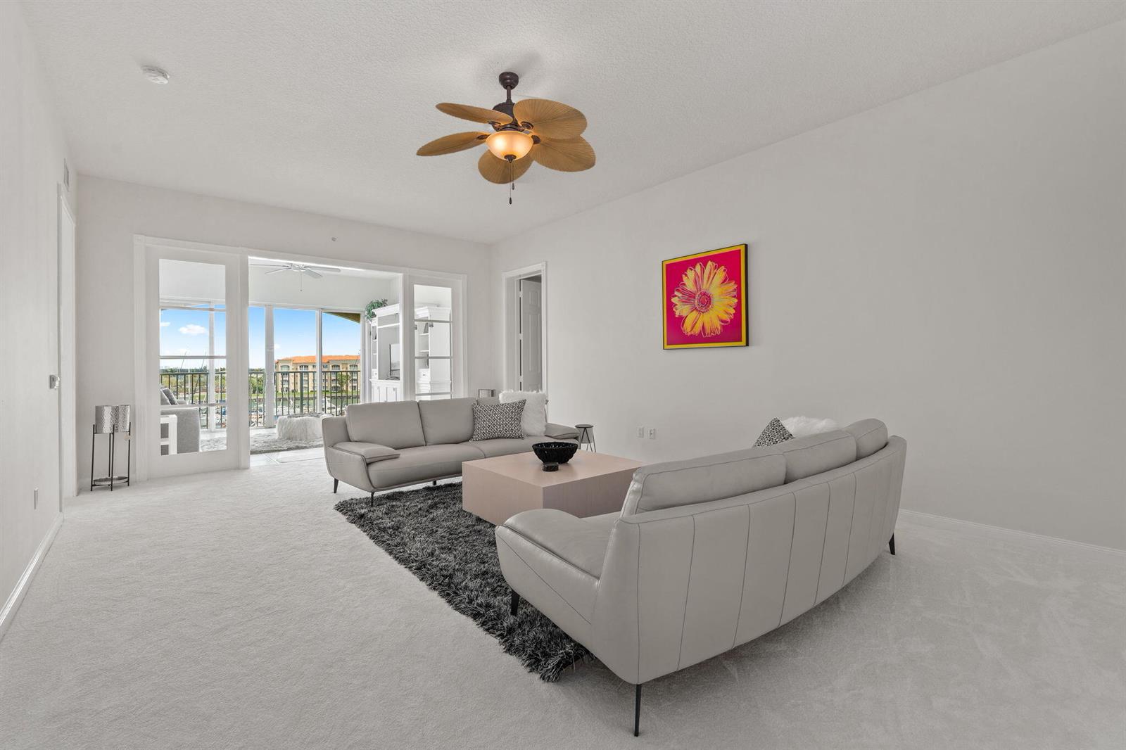 A living room features two light gray sofas, a dark rug, and a ceiling fan — 14 Harbour Isle Drive W, Fort Pierce FL 34949, FORT PIERCE, FL