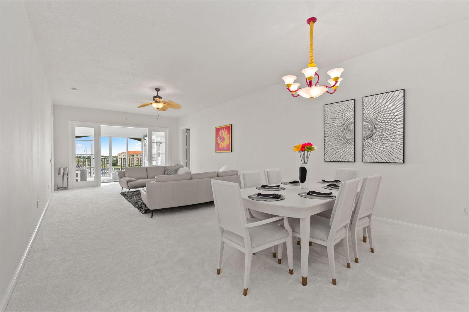 A dining area and living room with white carpet, white furniture, and a balcony view — 14 Harbour Isle Drive W, Fort Pierce FL 34949, FORT PIERCE, FL