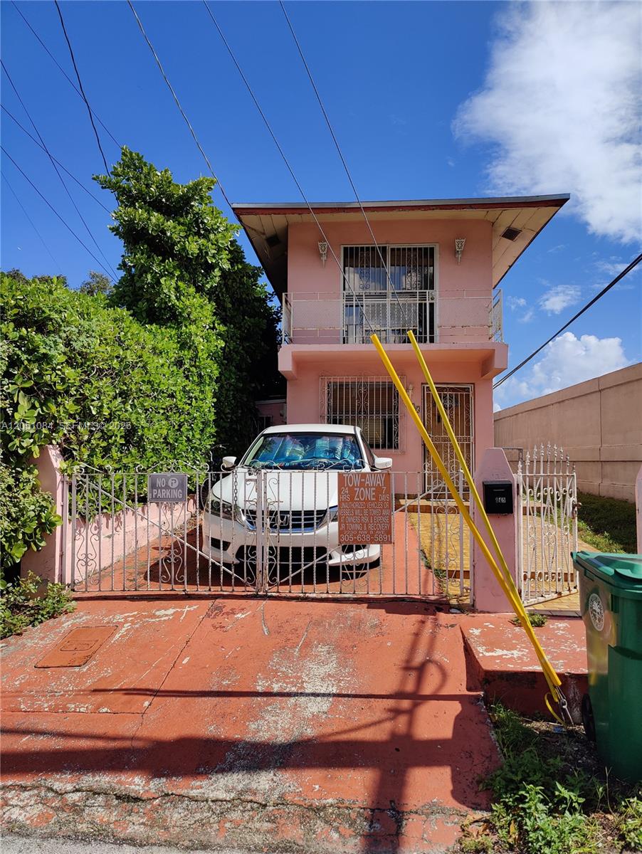 A two-story pink house with a white car parked behind a metal gate — 945 NW 19th Ave, Miami FL 33125, MIAMI, FL