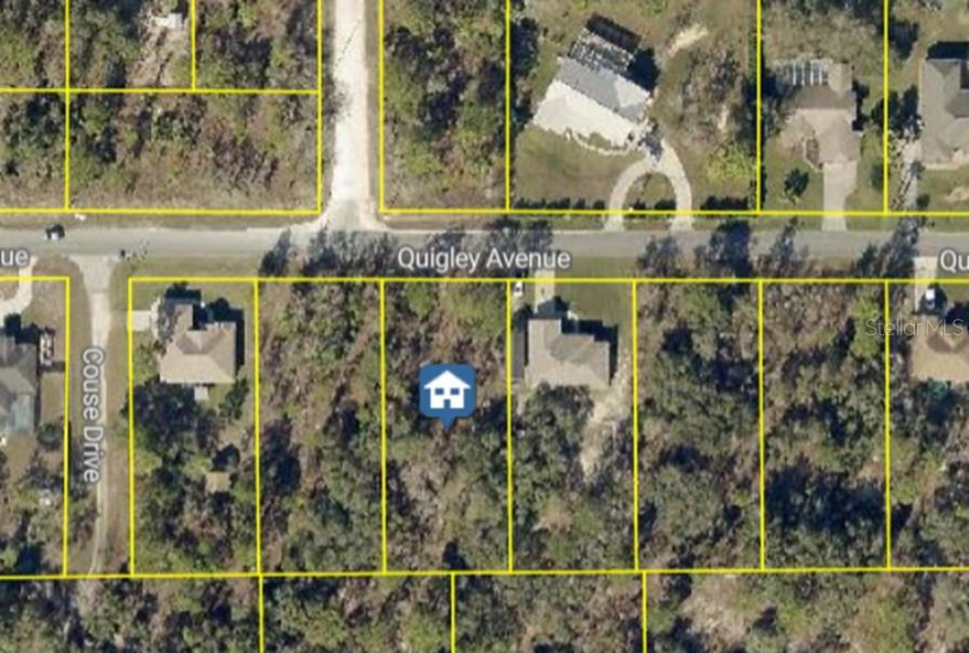 This is an aerial map view showing a vacant residential lot situated between two houses — 13070 QUIGLEY AVENUE, WEEKI WACHEE, FL