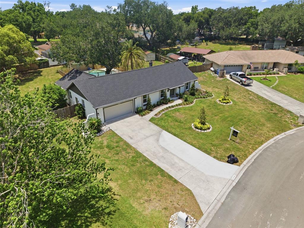 An aerial view shows a single-story house with a dark roof, white exterior, and driveway — 4110 HELENE PLACE, VALRICO, FL
