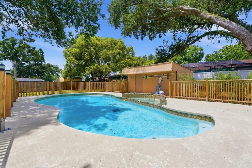 A backyard swimming pool with a small attached spa and a wooden fence — 4110 HELENE PLACE, VALRICO, FL