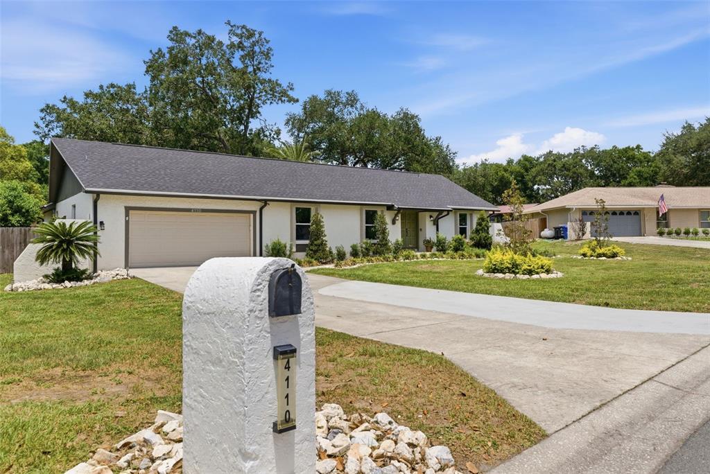 A single-story house with a white exterior, dark roof, and a concrete driveway — 4110 HELENE PLACE, VALRICO, FL