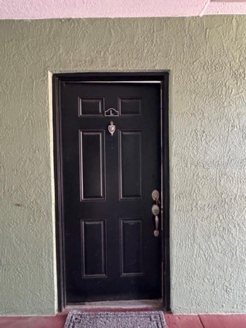 A black front door with a letter L plaque is set into a textured green wall — 2031 DIXIE BELLE DRIVE UNIT 2031L, ORLANDO, FL