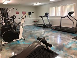 A gym room featuring exercise equipment, a glossy marbled floor, and a window with blinds — 7877 Golf Circle Drive # 211, Margate FL 33063, MARGATE, FL