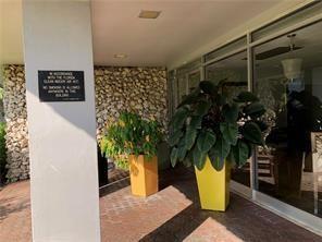 A covered building entrance features a stone wall, two potted plants, and a no-smoking sign — 7877 Golf Circle Drive # 211, Margate FL 33063, MARGATE, FL