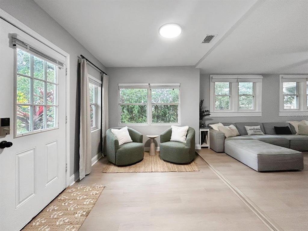 A living room features light wood flooring, two green armchairs, and a large gray sectional — 1718 LAVON STREET, LAKELAND, FL