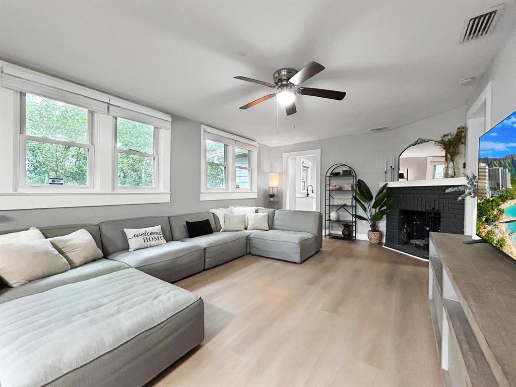 A living room features light wood flooring, a gray sectional sofa, and a corner fireplace — 1718 LAVON STREET, LAKELAND, FL