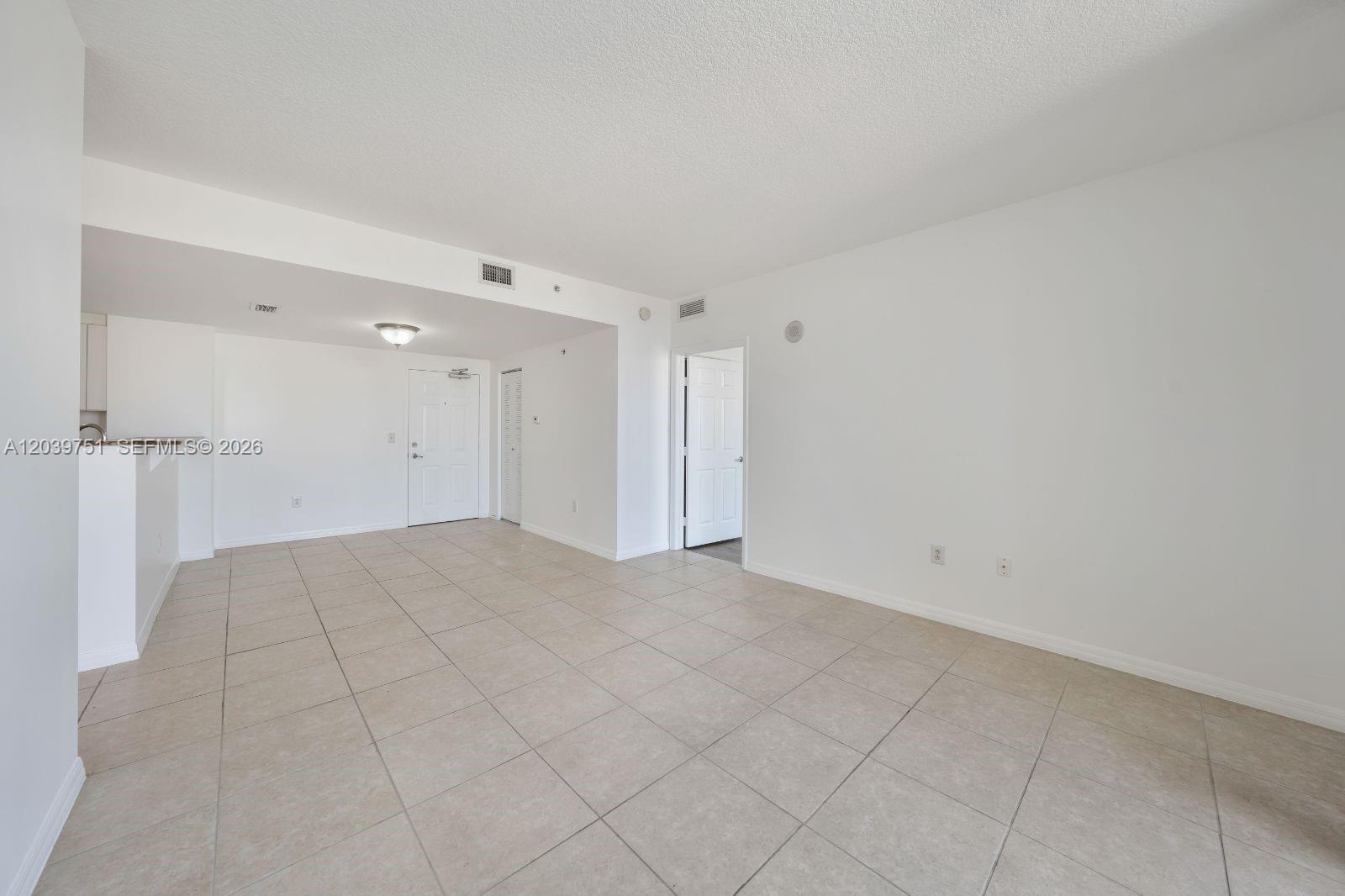 An empty room features white walls, beige tile flooring, and a doorway leading elsewhere — 215 SW 42nd Ave # 507, Miami FL 33134, MIAMI, FL