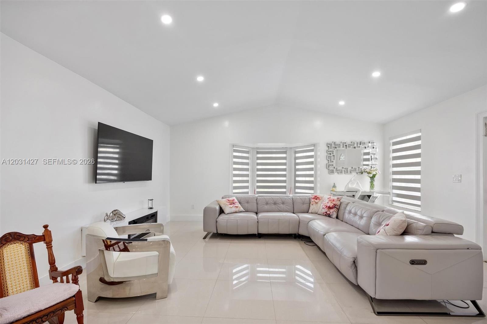 A bright living room features a large grey sectional sofa, a television, and tiled floors — 14623 SW 125th Pl, Miami FL 33186, MIAMI, FL
