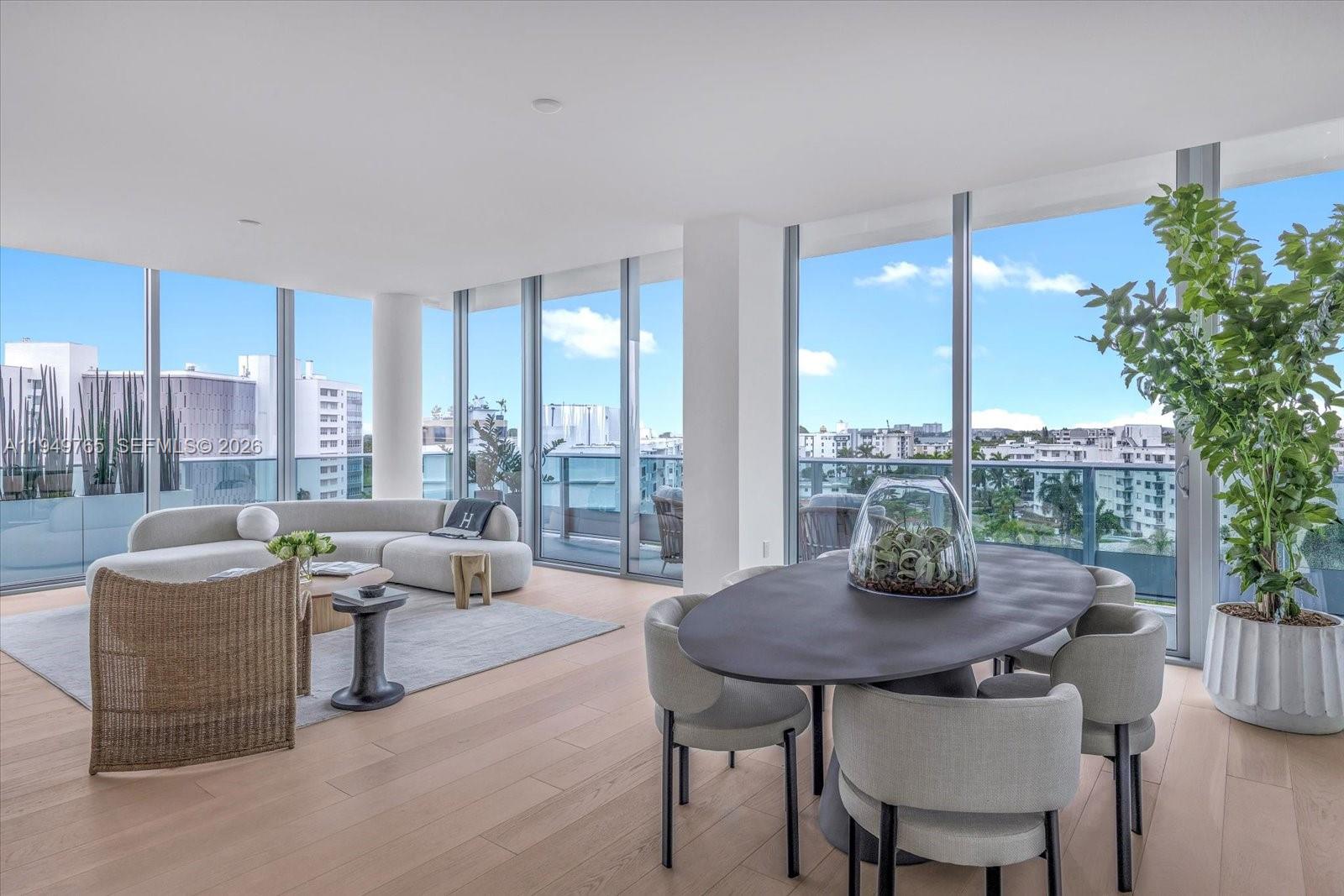 A modern living and dining area features floor-to-ceiling windows, light wood flooring, and neutral furniture — 9201 E Bay Harbor Dr, Bay Harbor Islands FL 33154, BAY HARBOR ISLANDS, FL