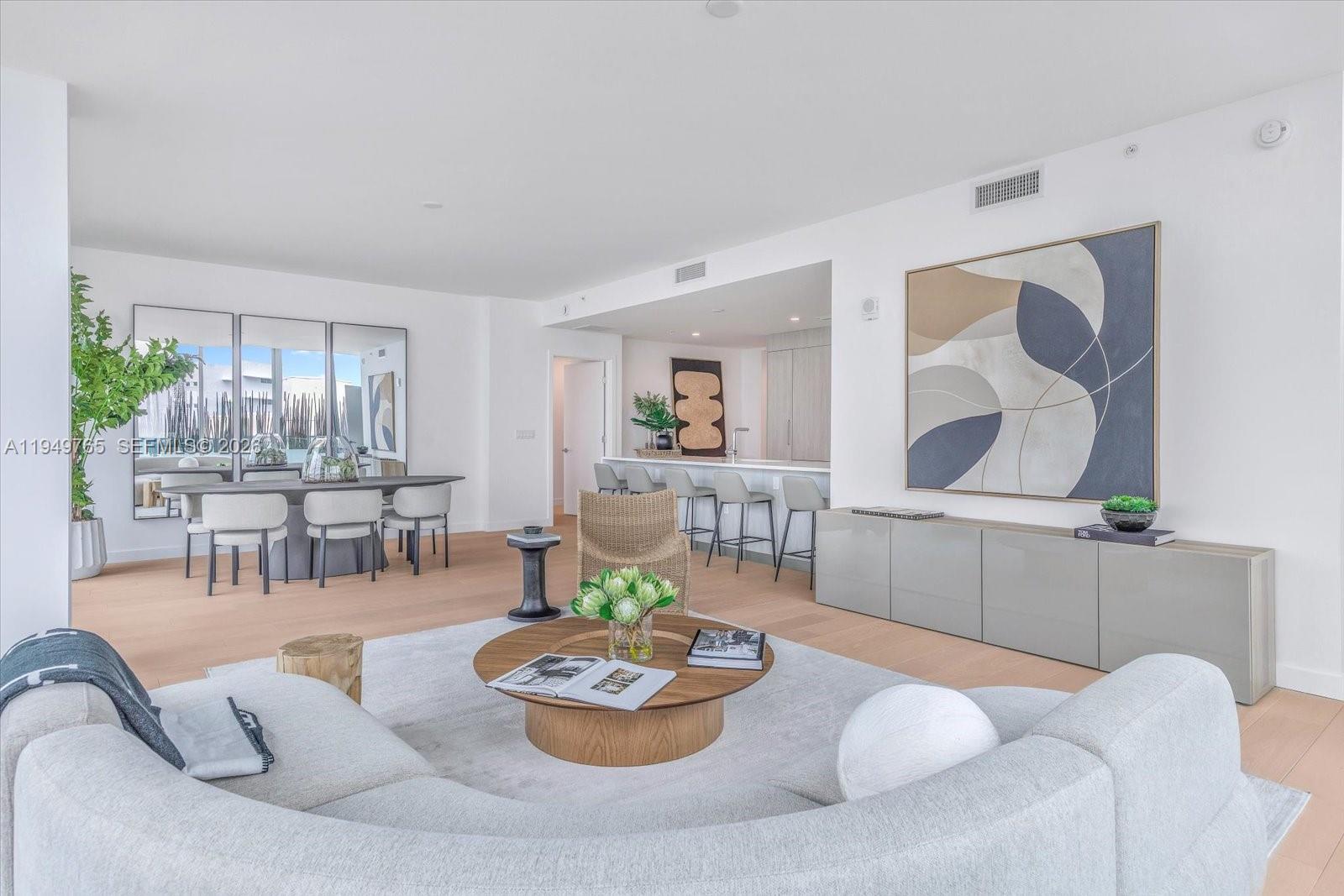 A bright, open-concept living and dining area features light wood floors and modern neutral furniture — 9201 E Bay Harbor Dr, Bay Harbor Islands FL 33154, BAY HARBOR ISLANDS, FL