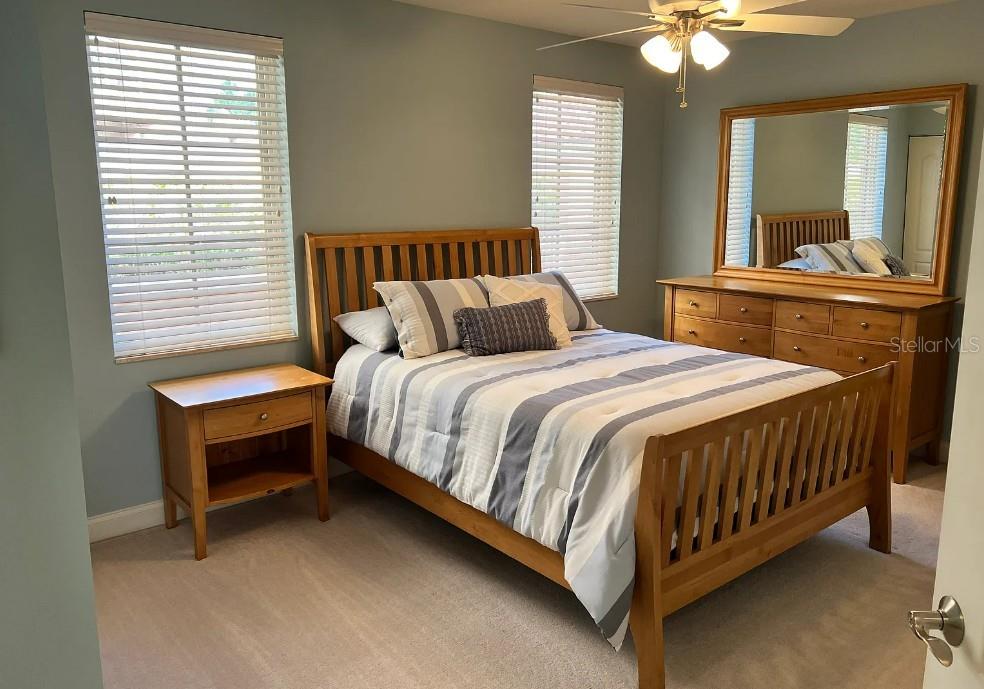 A bedroom features a wooden bed frame, matching dresser with mirror, and two windows with blinds — 505 MANDALAY AVENUE UNIT 72, CLEARWATER BEACH, FL