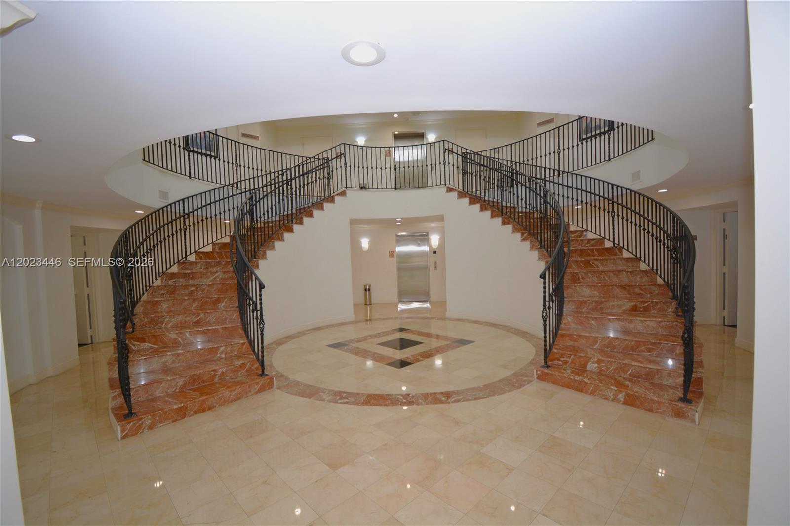 A grand foyer features a symmetrical double staircase with marble steps and wrought iron railings — 7765 SW 87th Ave # 207A, Miami FL 33173, MIAMI, FL